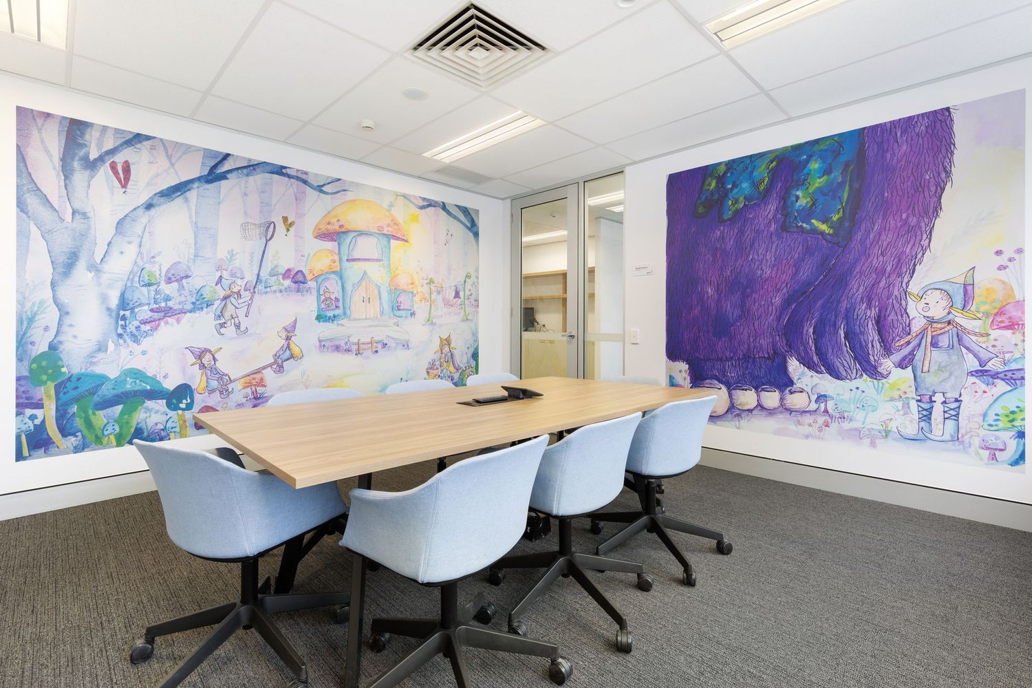 Interior photograph of a meeting room with a large colourful abstract mural.