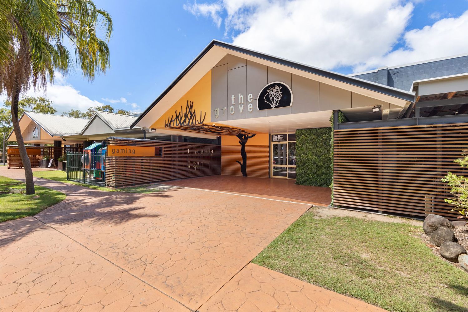 Exterior photograph of a residential home with palm tree landscaping.