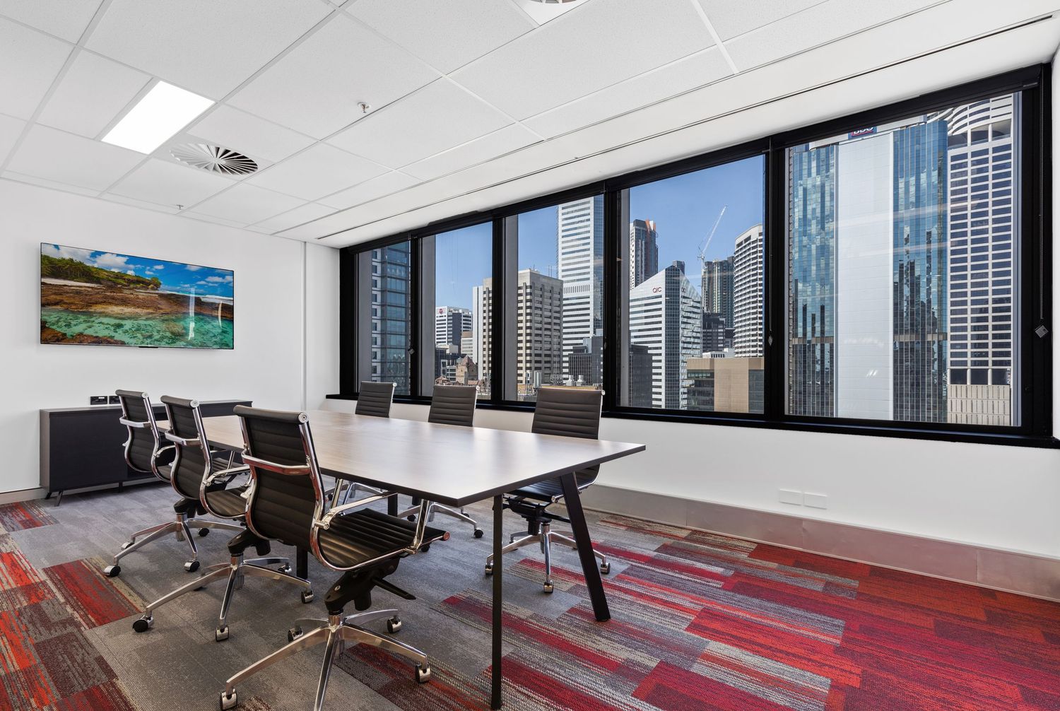 Interior photograph of a corporate boardroom with city skyline views.
