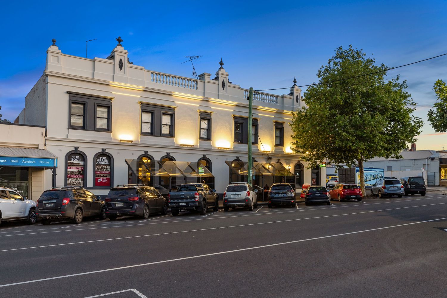 Exterior photograph of a heritage streetscape building at dusk.
