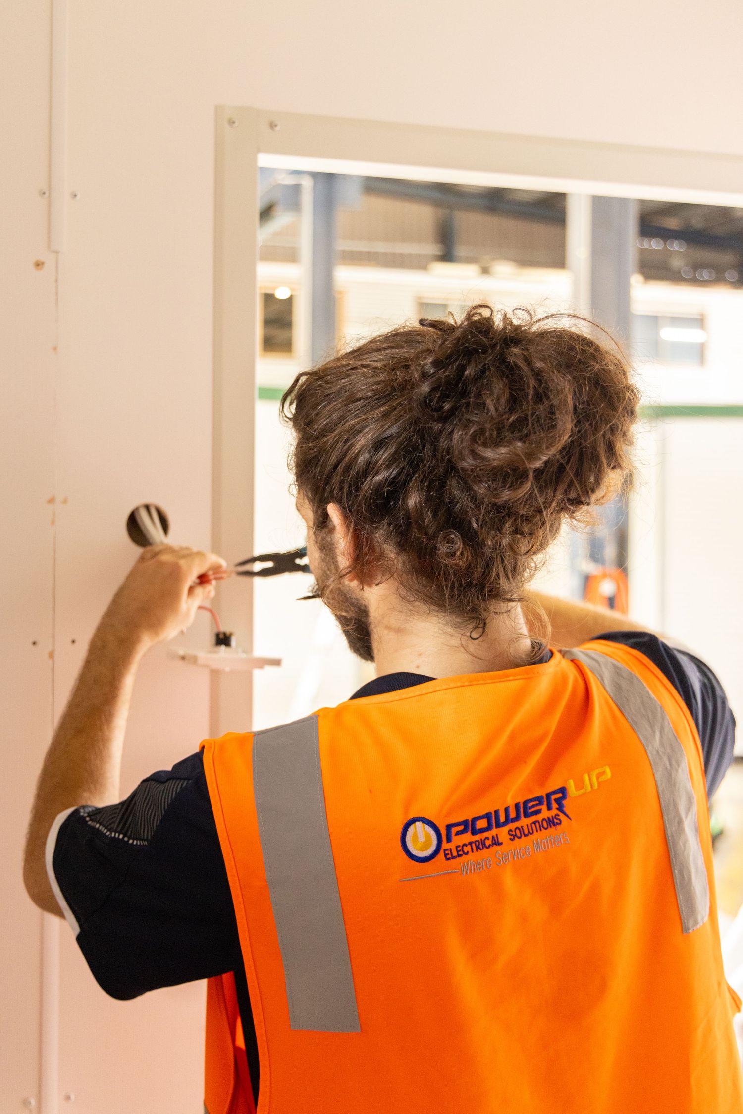 Photograph of a tradesperson in hi-vis workwear for the Powerup brand.