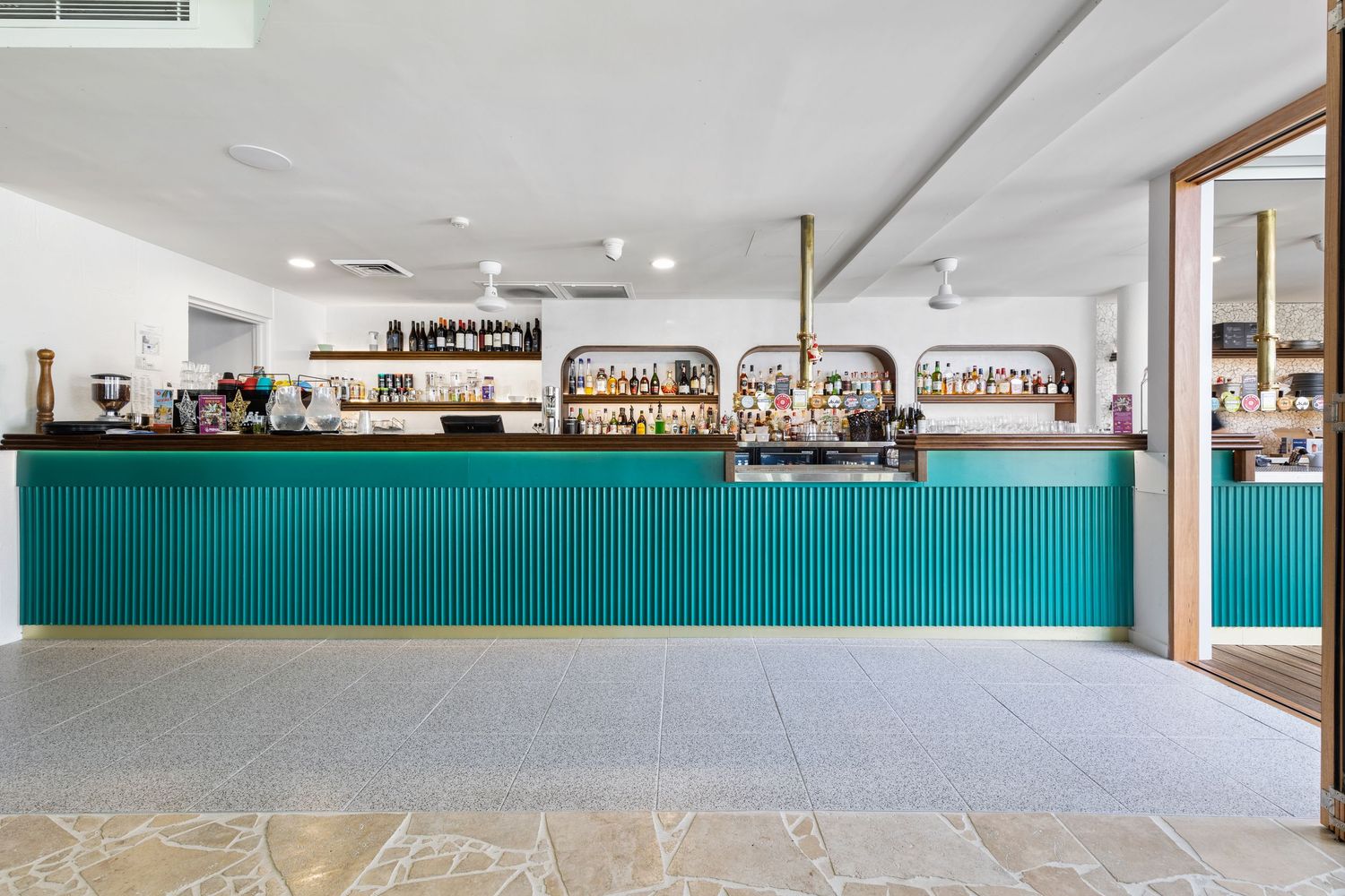 Interior photograph of a retail or cafe counter with teal cabinetry.