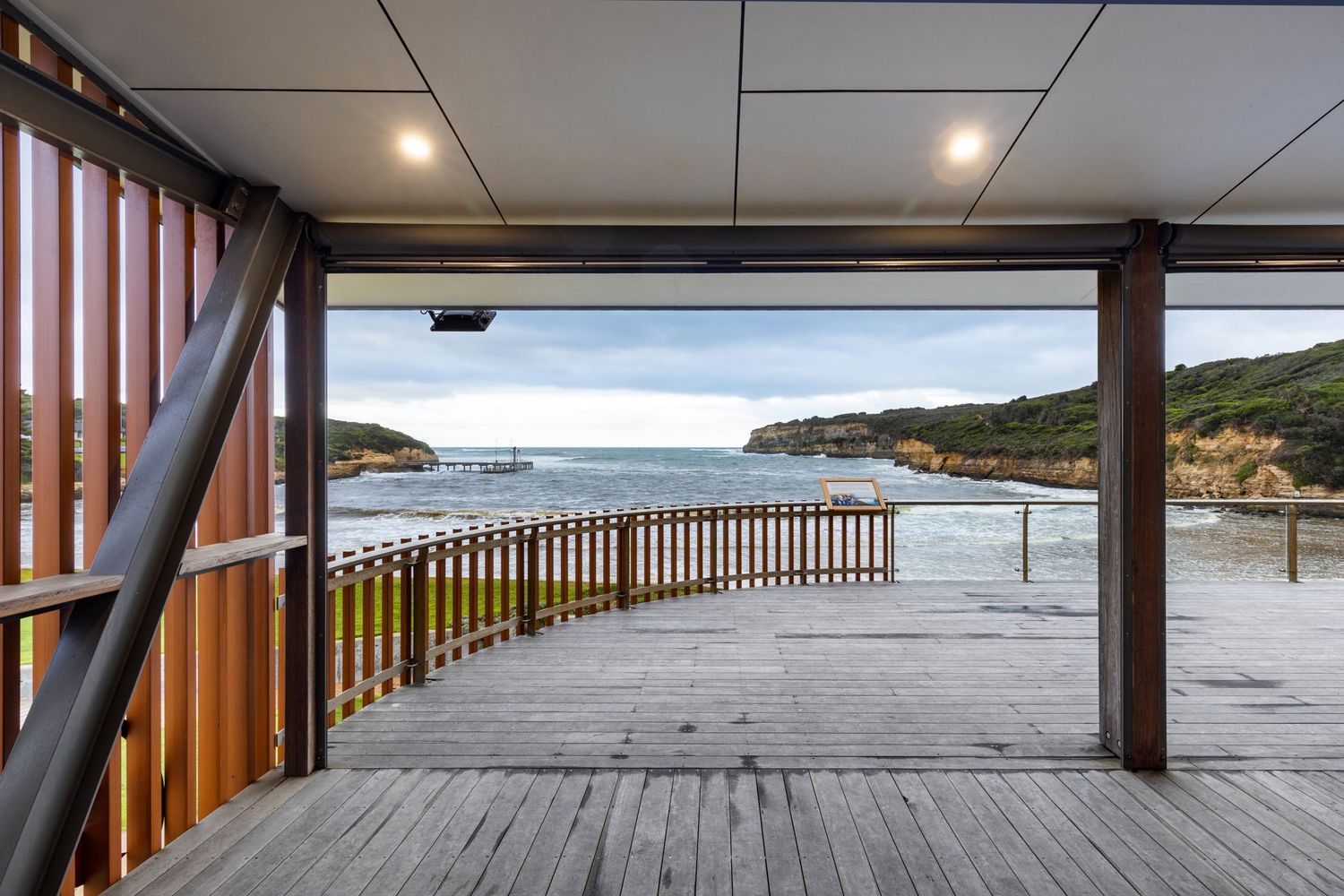 Photograph of a timber-framed coastal deck structure overlooking the water.