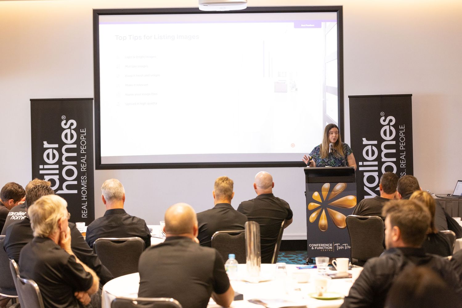 Photograph of a presenter addressing attendees at the Cavalier Homes national conference.