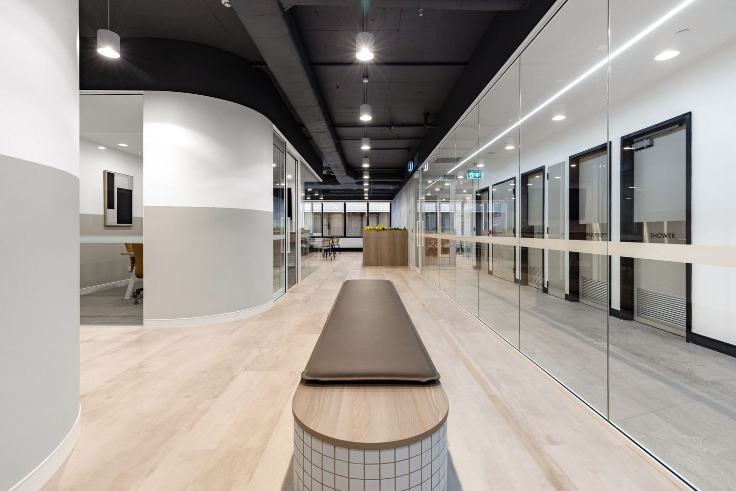 Interior photograph of a retail or office fit-out corridor with display cabinetry.
