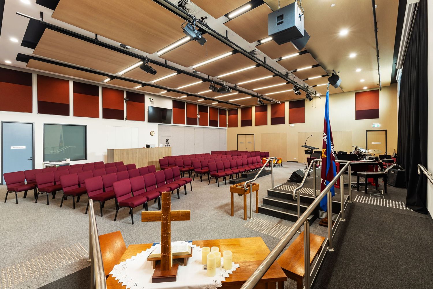 Interior photograph of a council chamber or auditorium with tiered red seating.