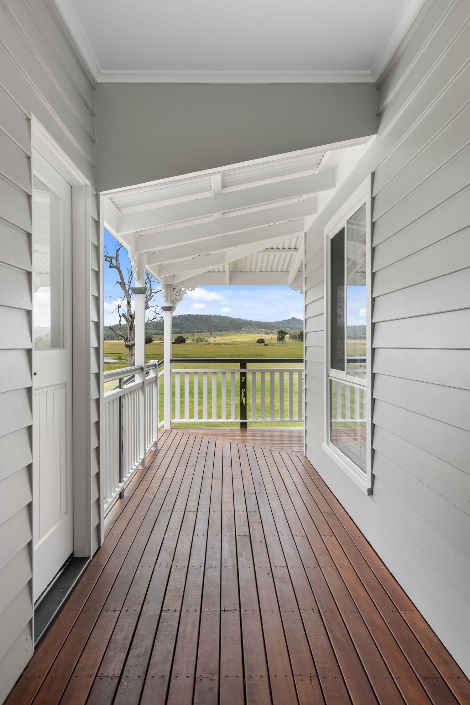 Photograph of a timber-decked verandah with coastal views.