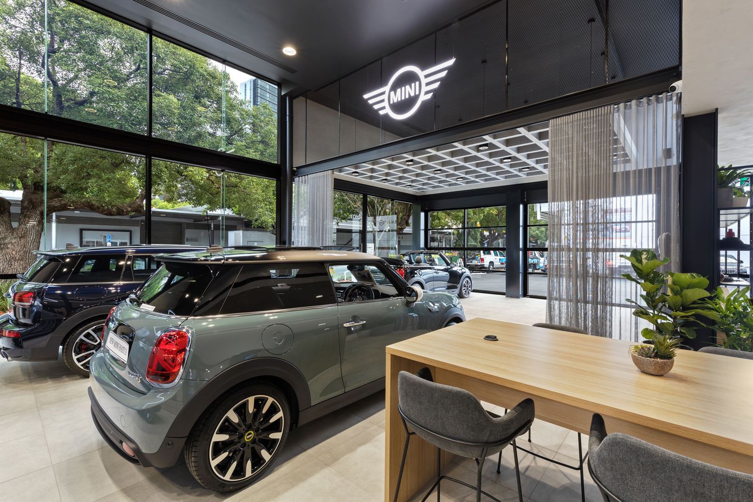 Interior photograph of a MINI car dealership showroom with vehicle on display.
