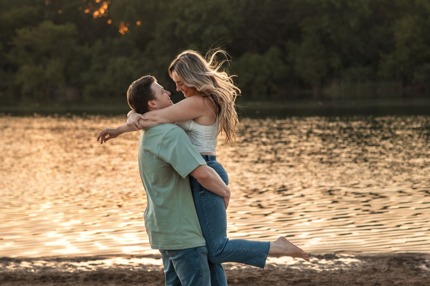 Couple embraces and spins in the sand at Island Lake State Park in Brighton Michigan by Rachel Martinez Photography