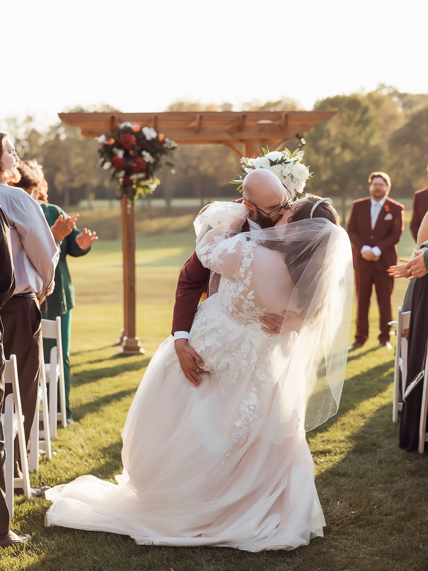 Couple dips for a kiss at their ceremony at Fox Hills in Plymouth Michigan by Rachel Martinez Photography, Michigan wedding photographer