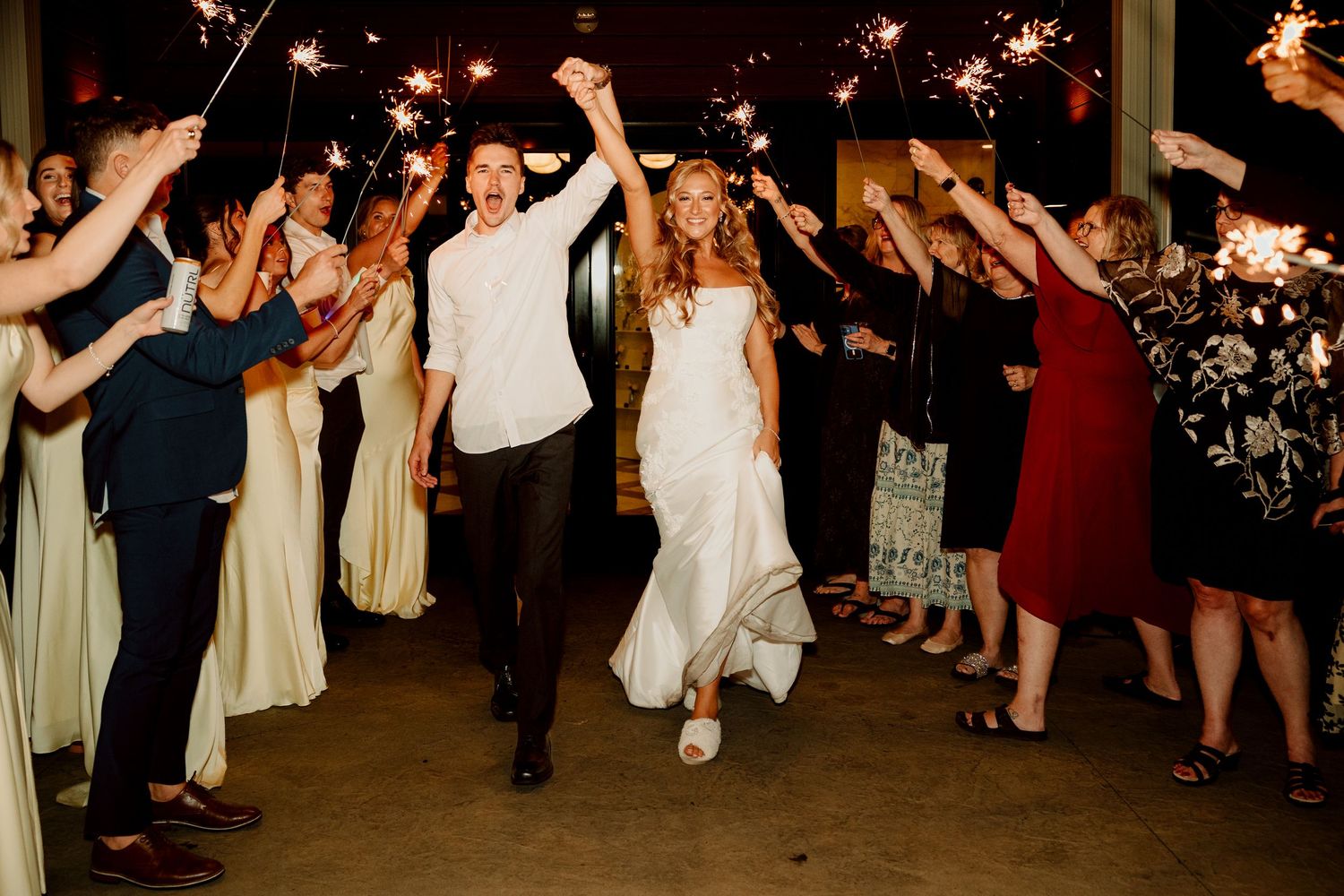 Couple exists during a sparkler send off at White Birch Wedding Barn in Cement City Michigan by Rachel Martinez Photography