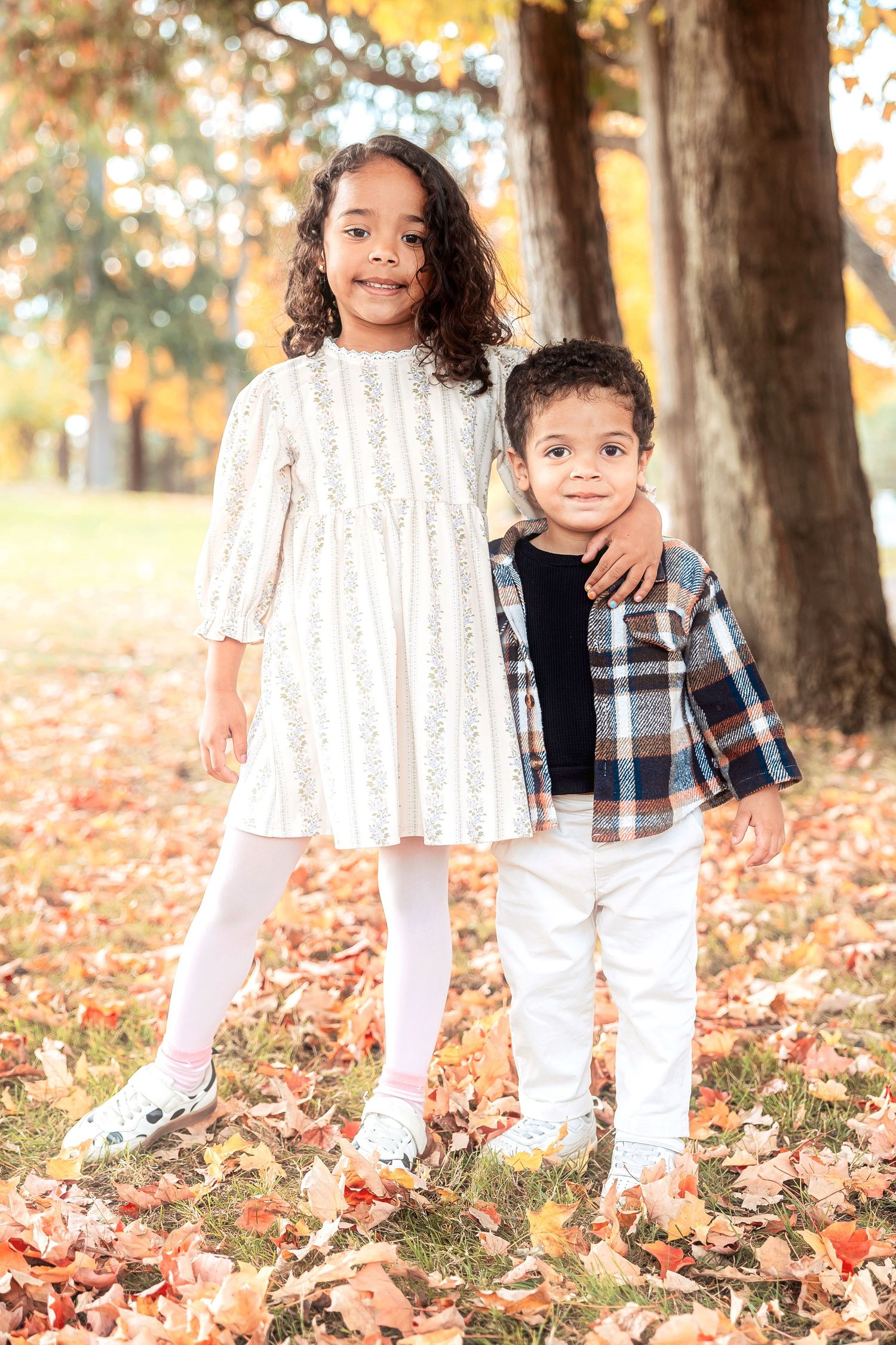 Siblings pose in fallen leaves in Livonia at Greenmead by Rachel Martinez Photography, Michigan photographer