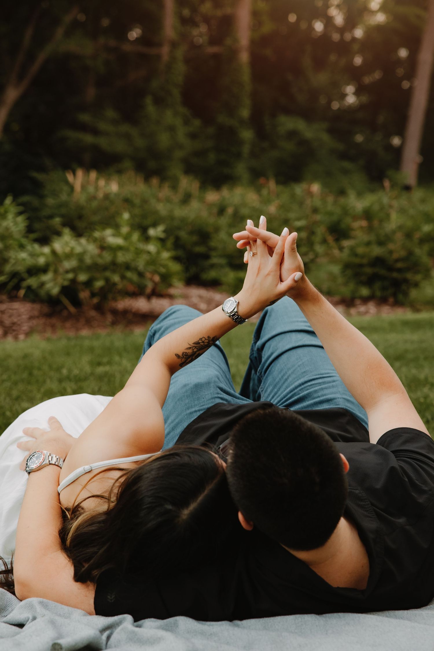 Couple holds hands on a blanket in the UM Arb by Rachel Martinez Photography, Michigan Wedding photographer