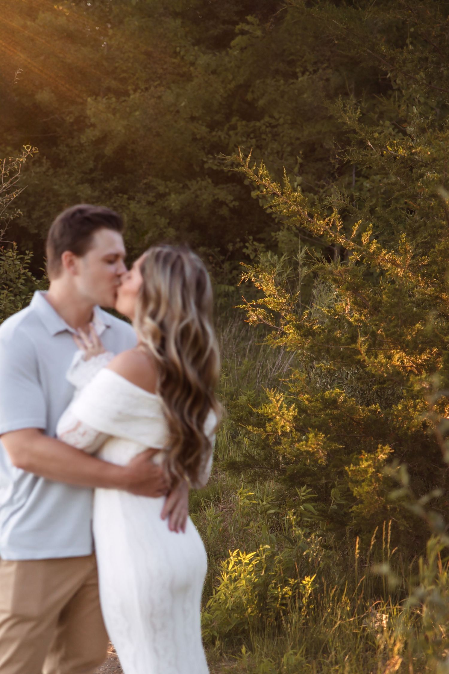 Couple kisses in the sunlight at Island Lake State Park in Brighton Michigan by Rachel Martinez Photography