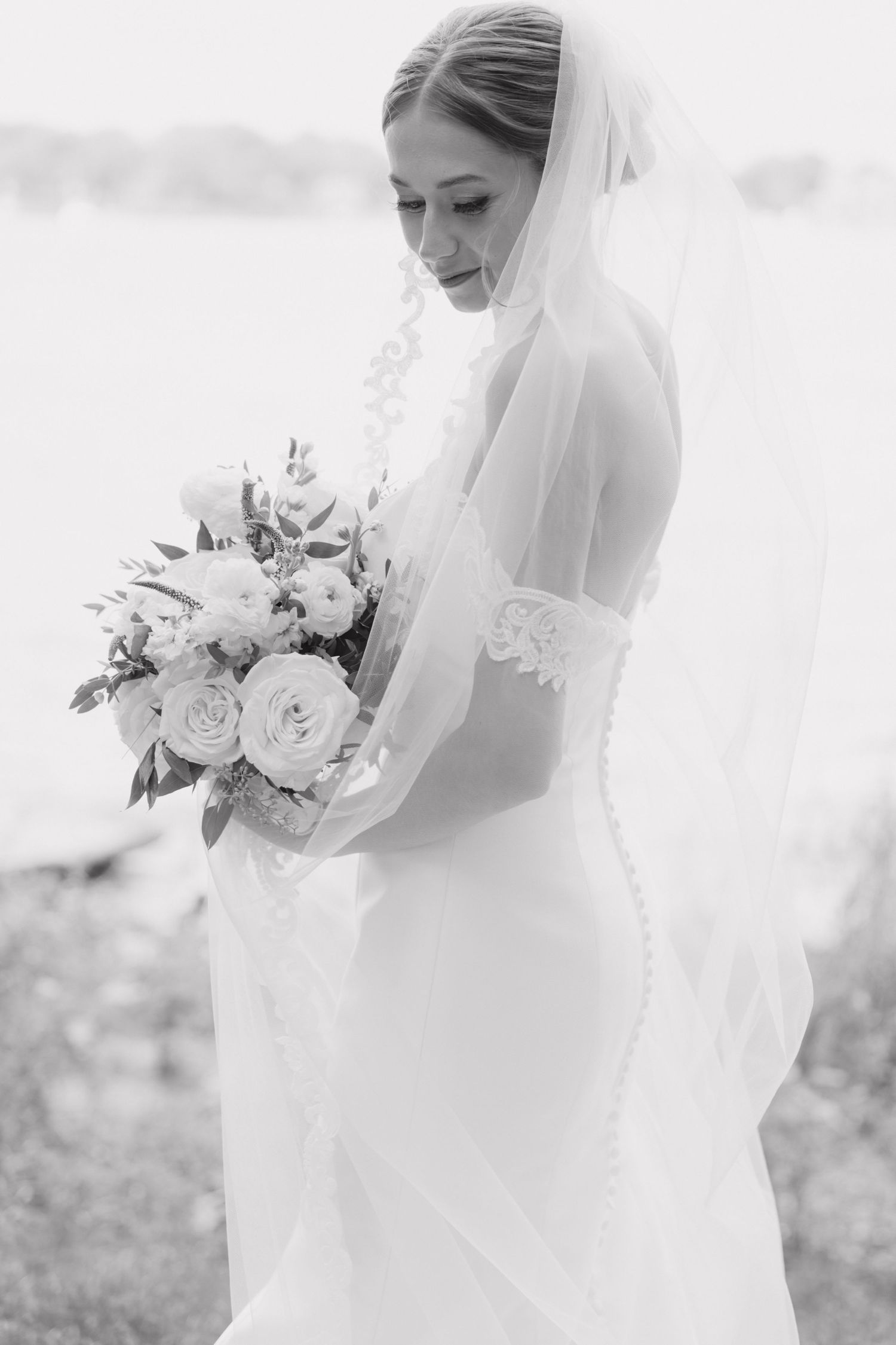 Bride holds her bouquet in a black and white portrait at BoatWerks on the water by Rachel Martinez Photography, Michigan wedding photographe
