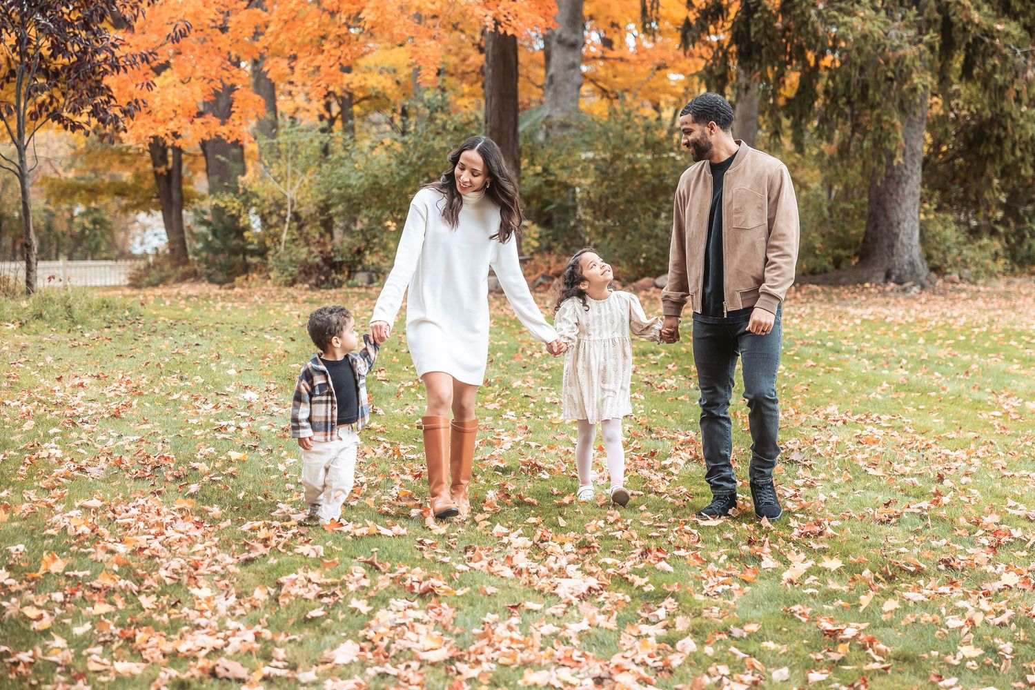 Family of four walk in fallen leaves in Livonia at Greenmead by Rachel Martinez Photography, Michigan photographer