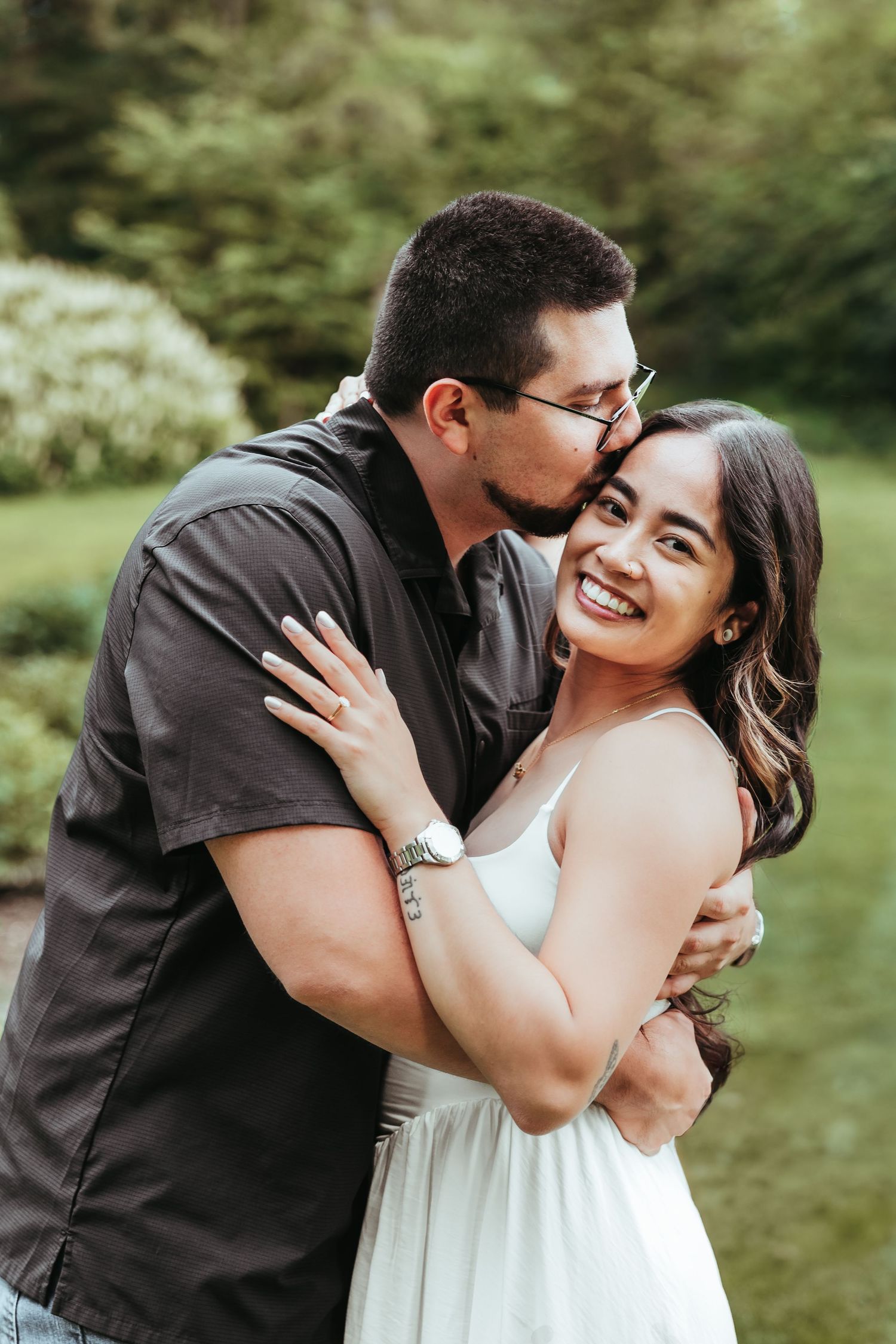 Couple holds each other while he kisses her in the UM Arb by Rachel Martinez Photography, Michigan Wedding photographer