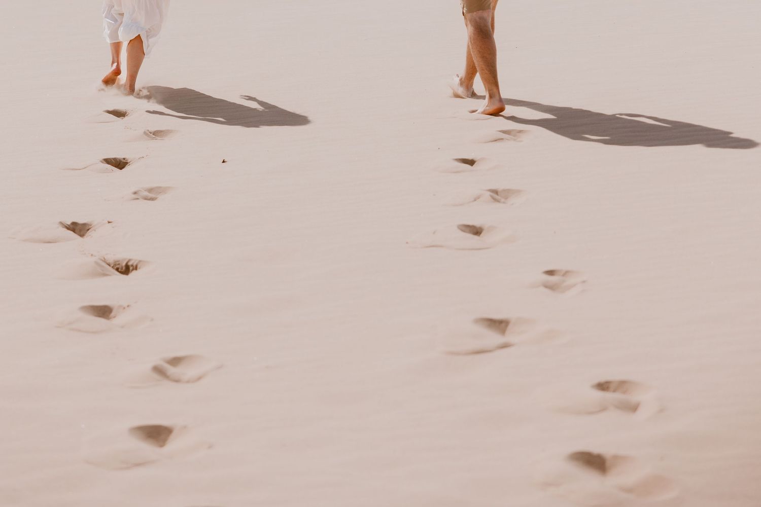 Footprints and shadows of couple walking togetherat Silver Lake Sand Dunes on Lake Michigan by Rachel Martinez Photography