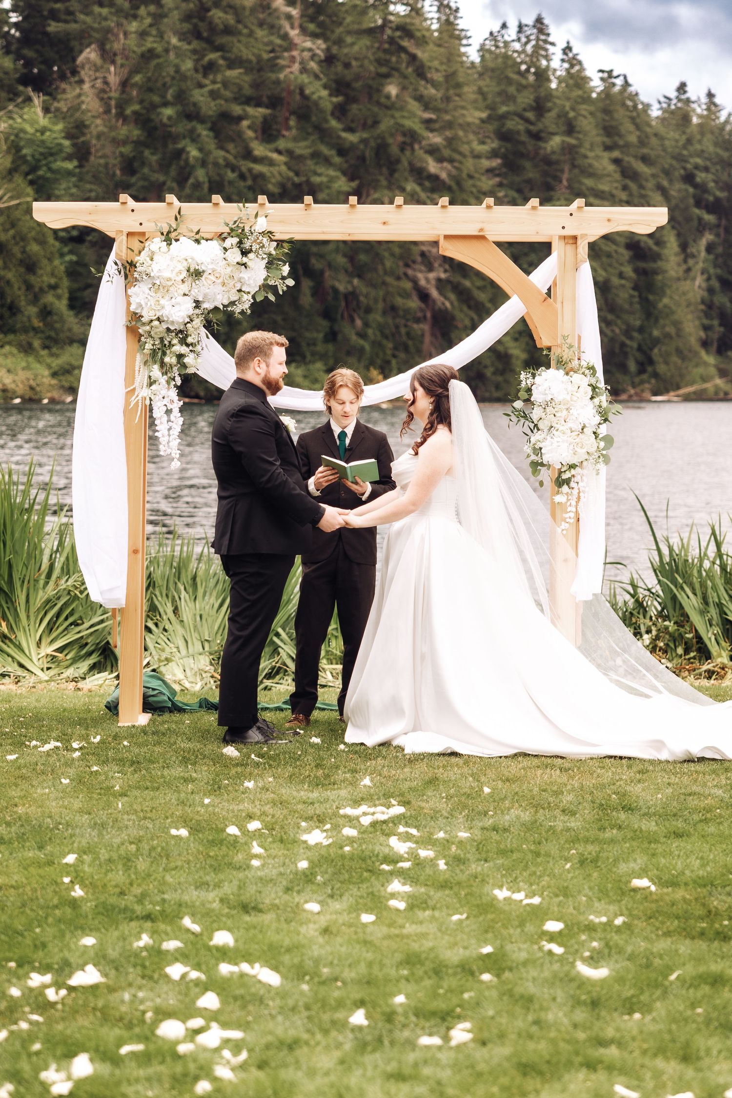 Couple holds hands in front of their wedding arch in Seattle Washington by wedding photographer Rachel Martinez Photography Novi, Michigan