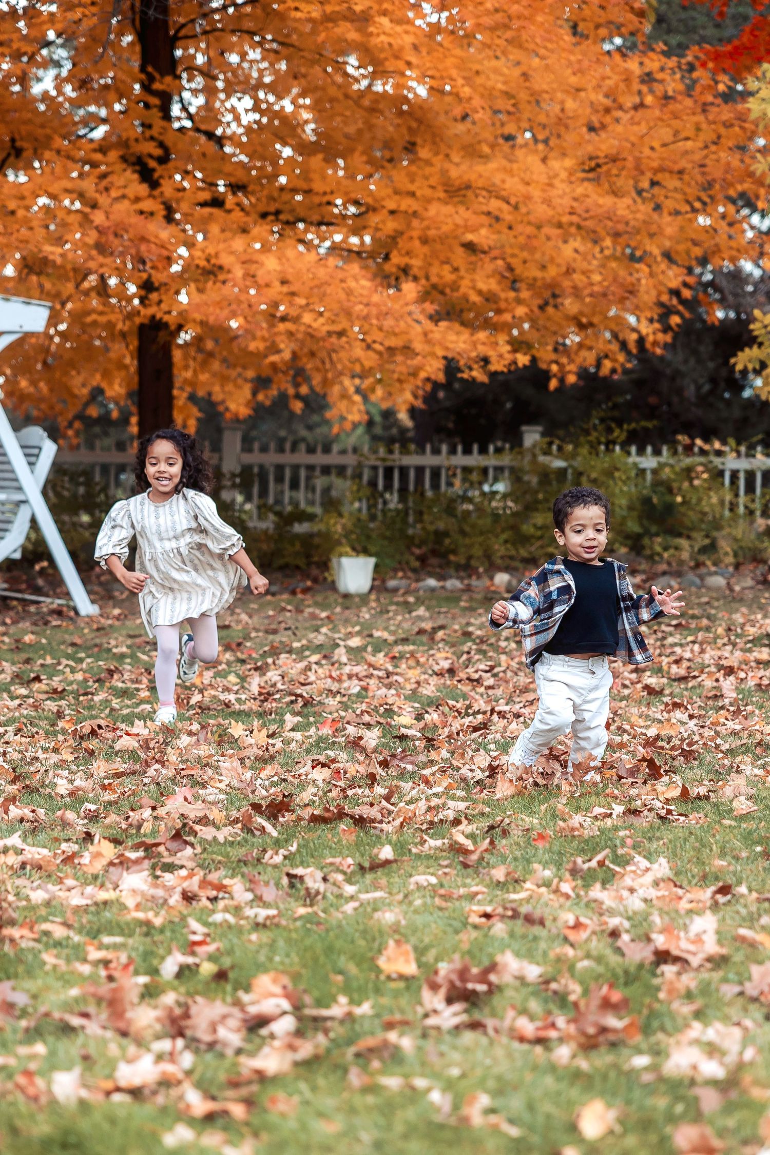 Kids run in fallen leaves in Livonia at Greenmead by Rachel Martinez Photography, Michigan photographer