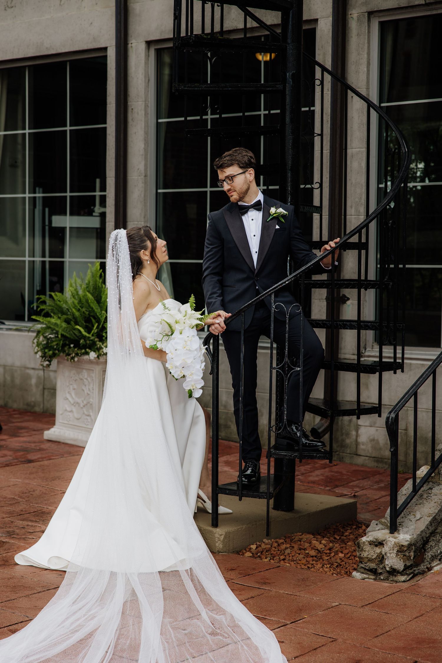 Couple poses on metal winding stairs at Pine Knob Mansion by wedding photographer Rachel Martinez Photography Novi, Michigan
