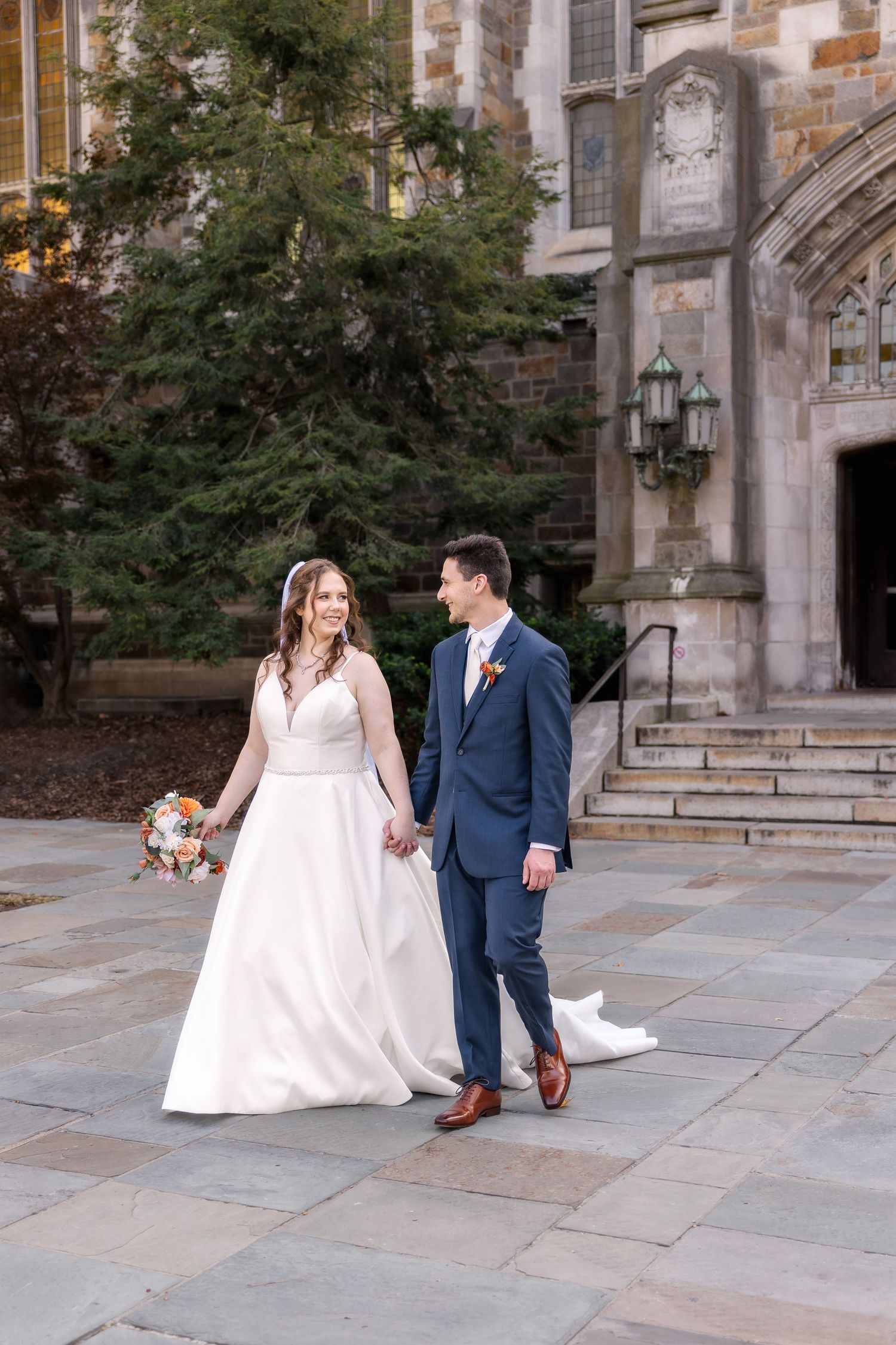 Couple holds hands and walks during their wedding portraits at the University of Michigan Law Quad by Rachel Martinez Photography, Michigan