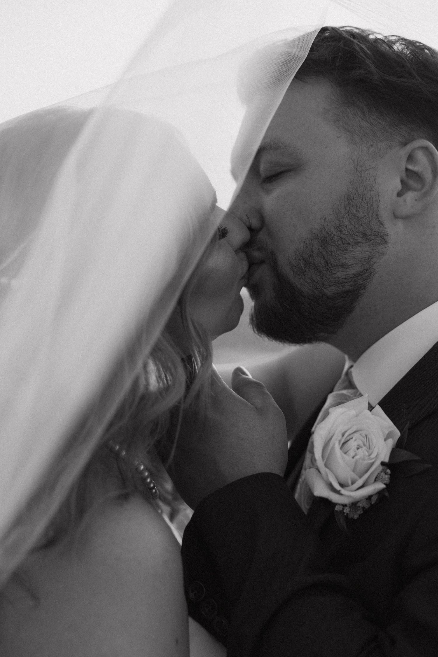 Couple kisses under a veil on the roof of the Lafayette Grand in Pontiac Michigan by wedding photographer Rachel Martinez Photography