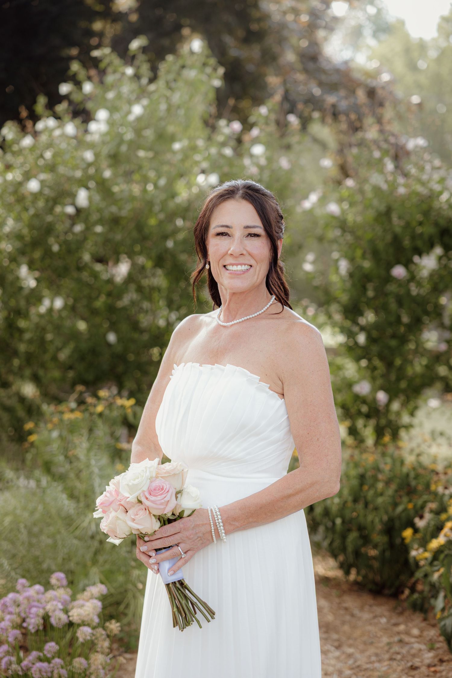 Bride poses at Bed and Breakfast gardens in Clarkston, Michigan by Rachel Martinez Photography, Michigan wedding photographer