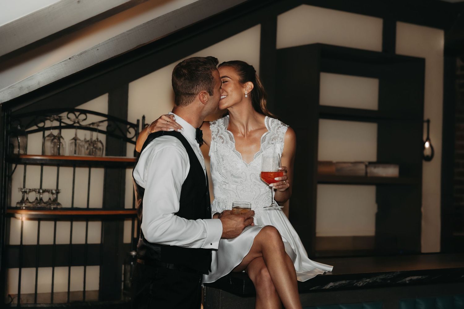 Couple embraces with drinks in speakeasy bar at St. Clair Inn by Rachel Martinez Photography, Michigan wedding photographer
