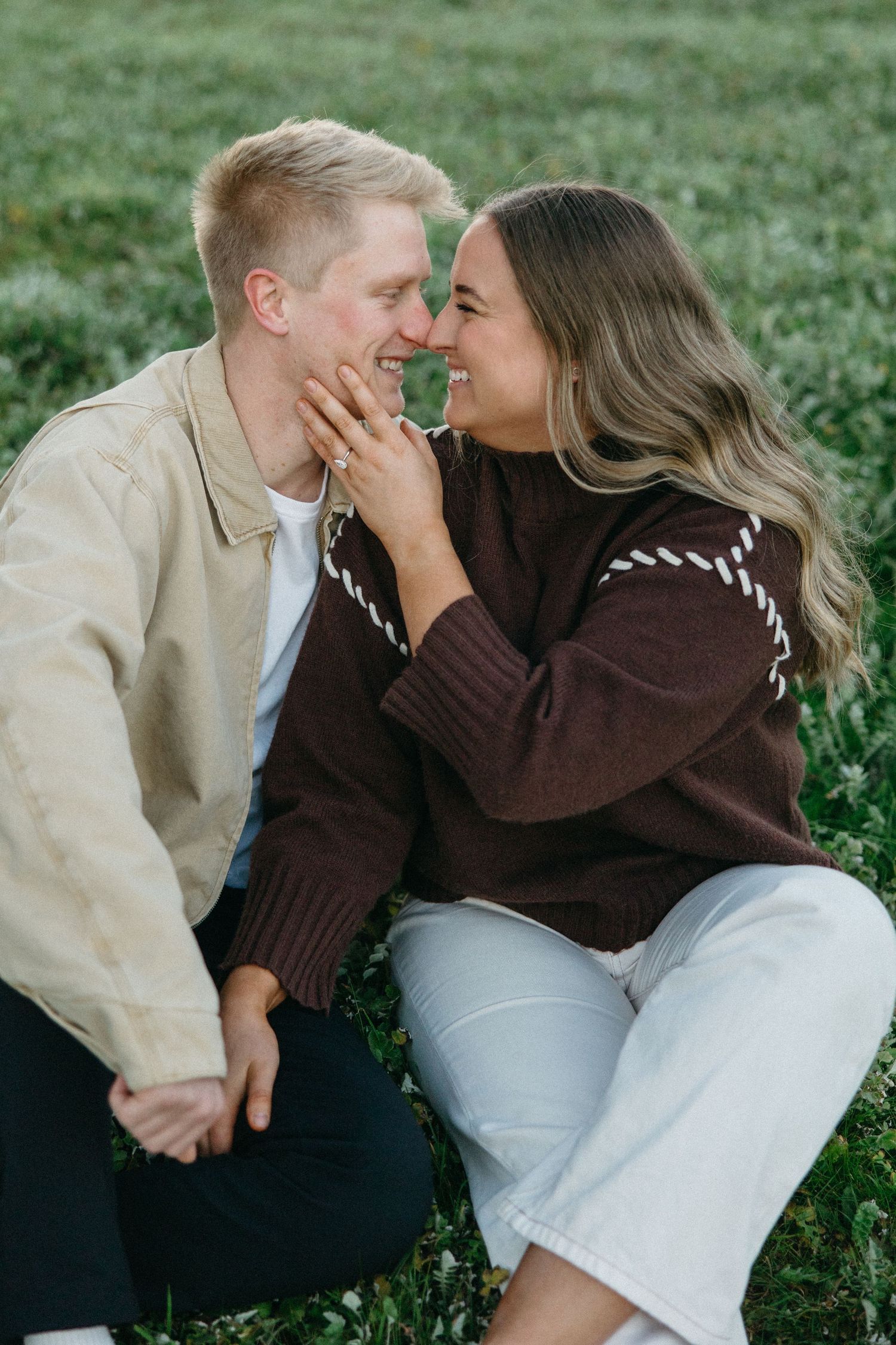 couple sitting in the grass cuddling