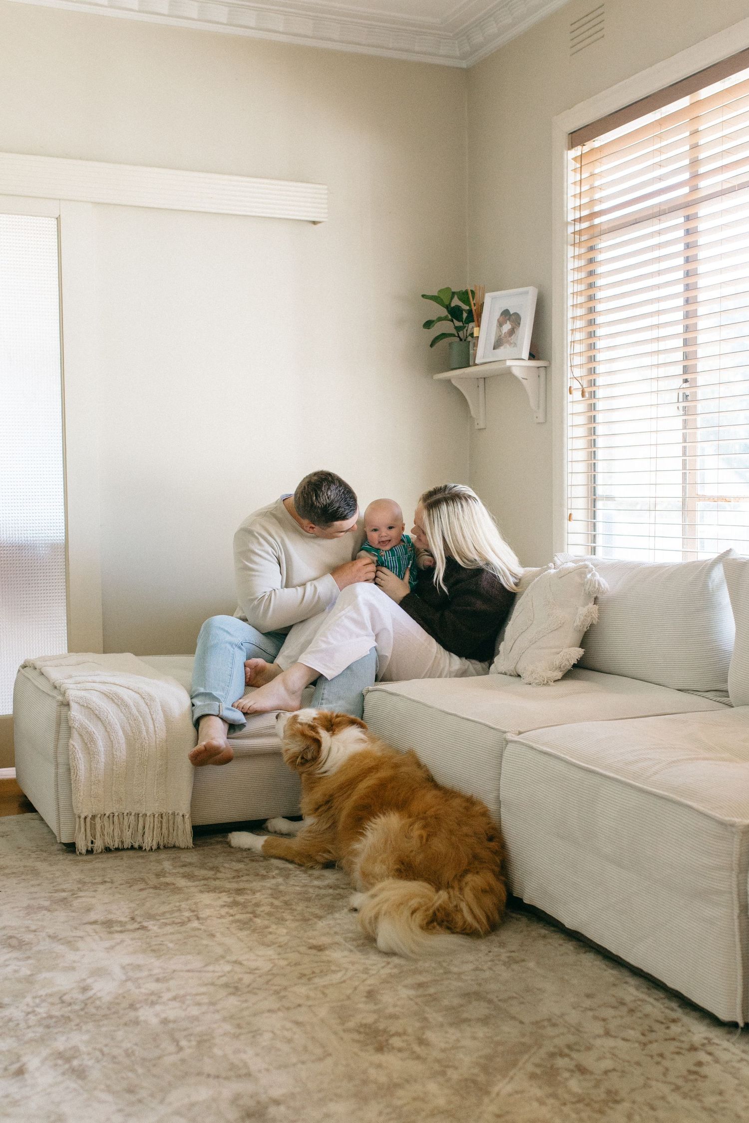 family cuddling on couch inside their home
