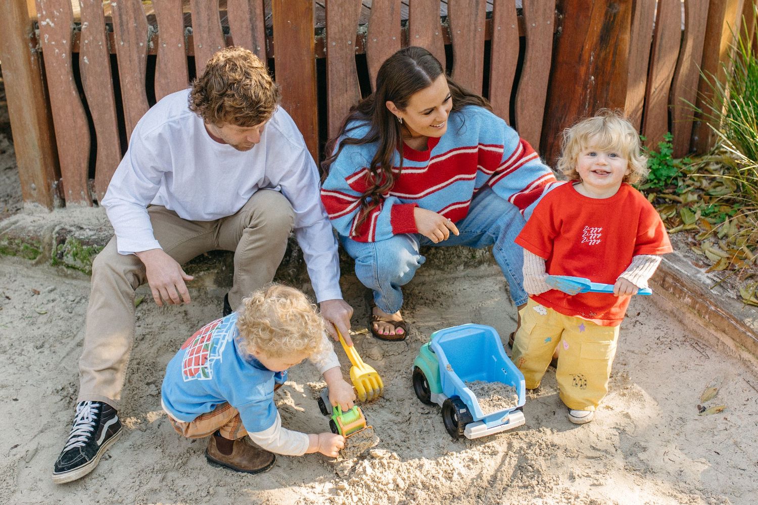 Family playing together in a sandpit