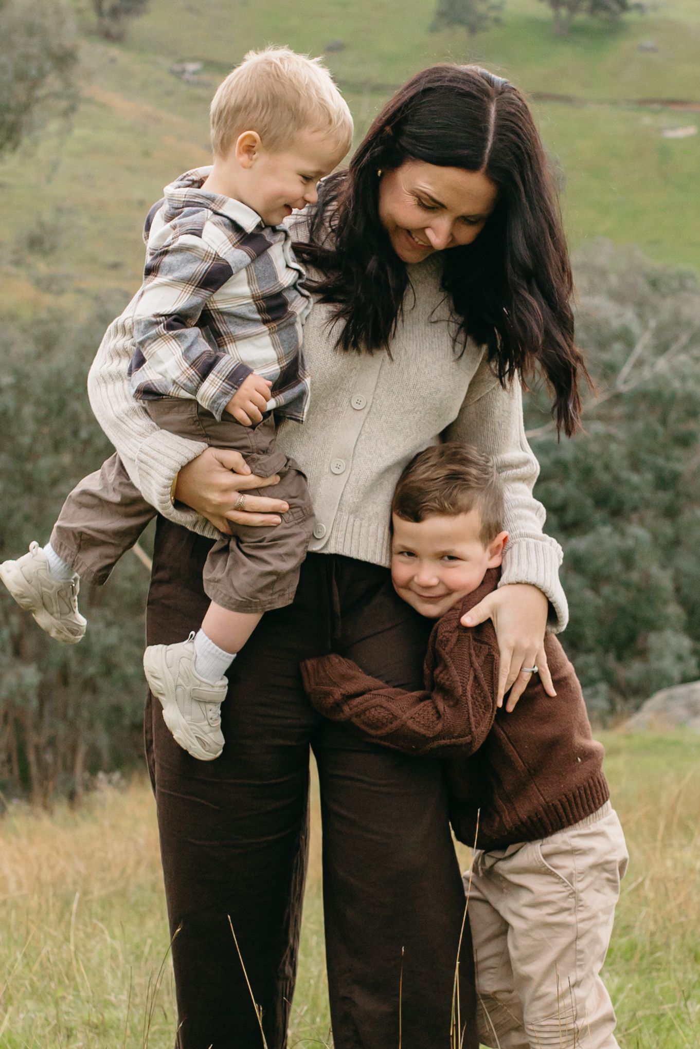 mum being cuddled by her two sons outside