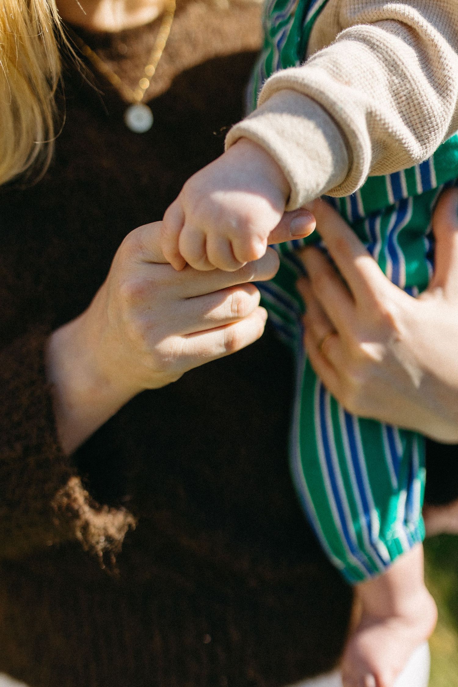 baby holding mums finger