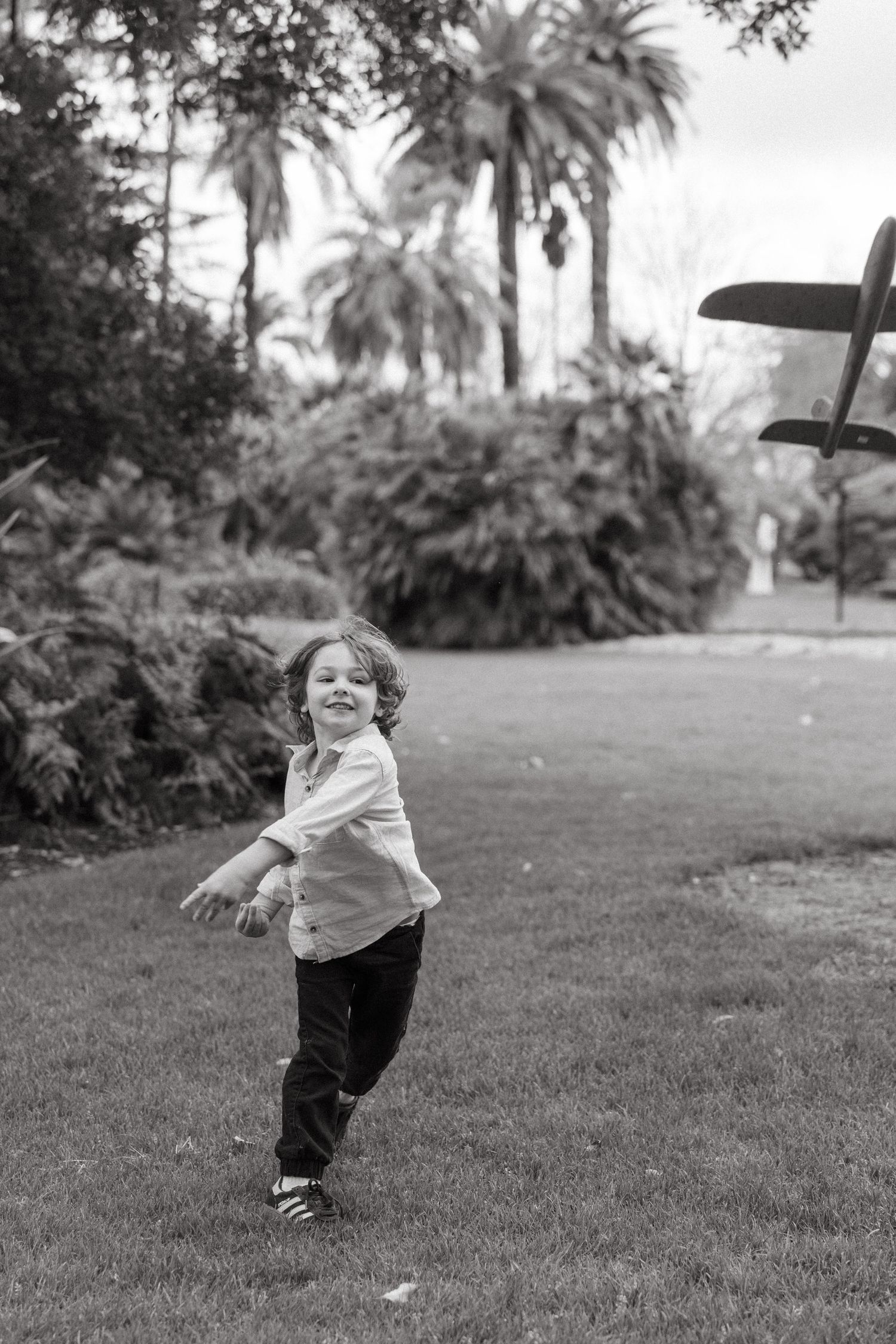 boy throwing toy plane outside