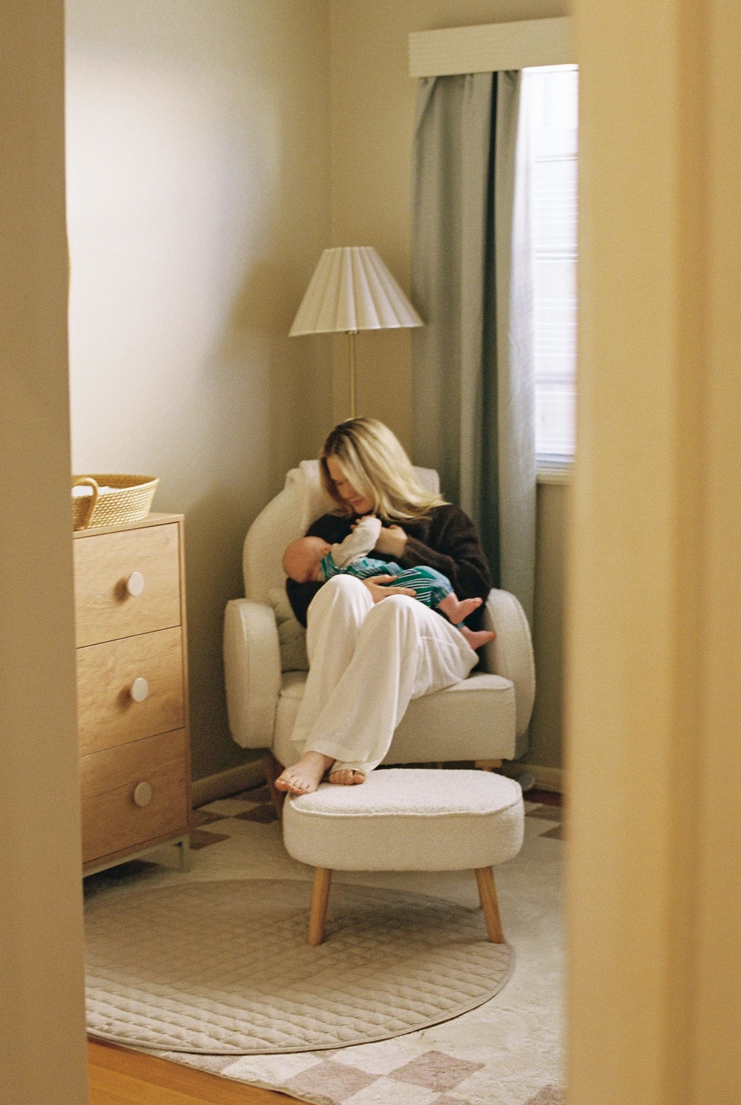 woman breastfeeding her baby in a rocking chair captured on 35mm film