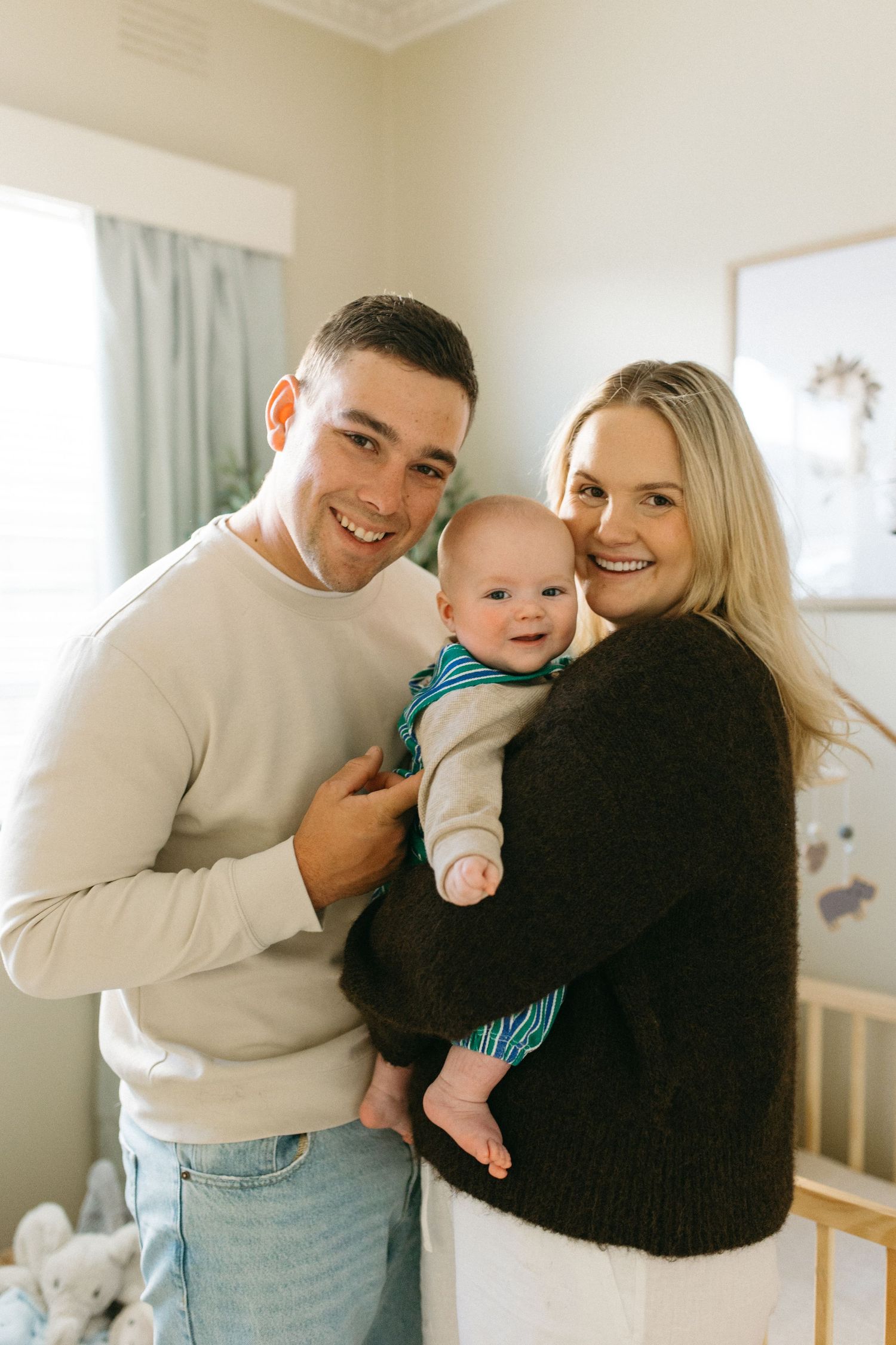 family smiling at camera in baby nursery