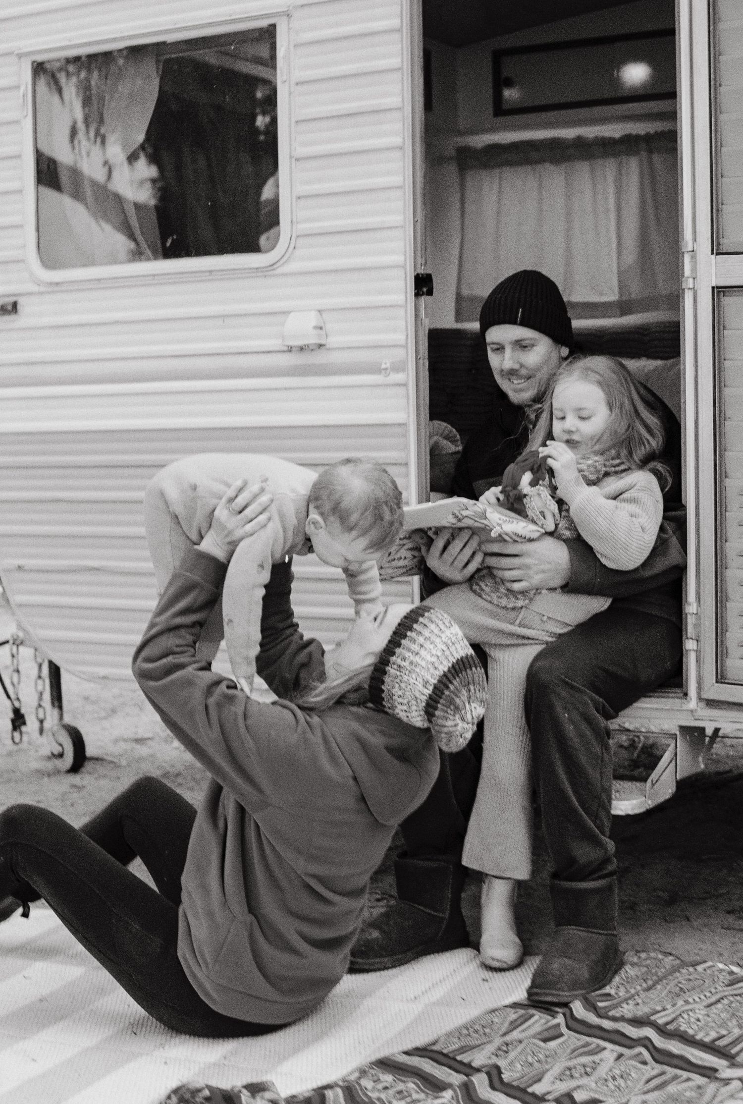 family cuddling outside caravan captured on 35mm film