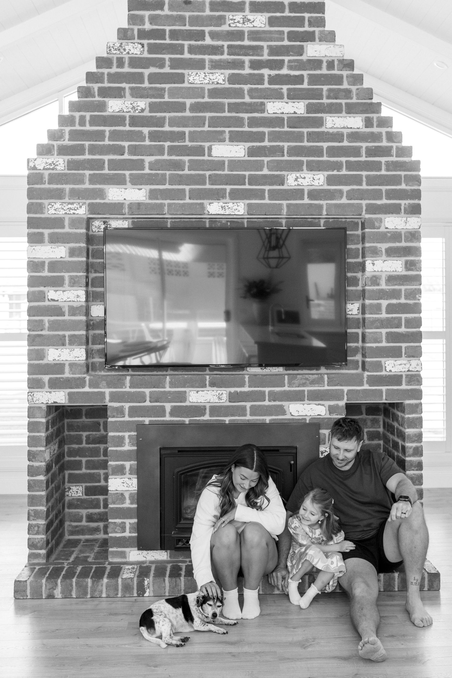 family sitting by fireplace