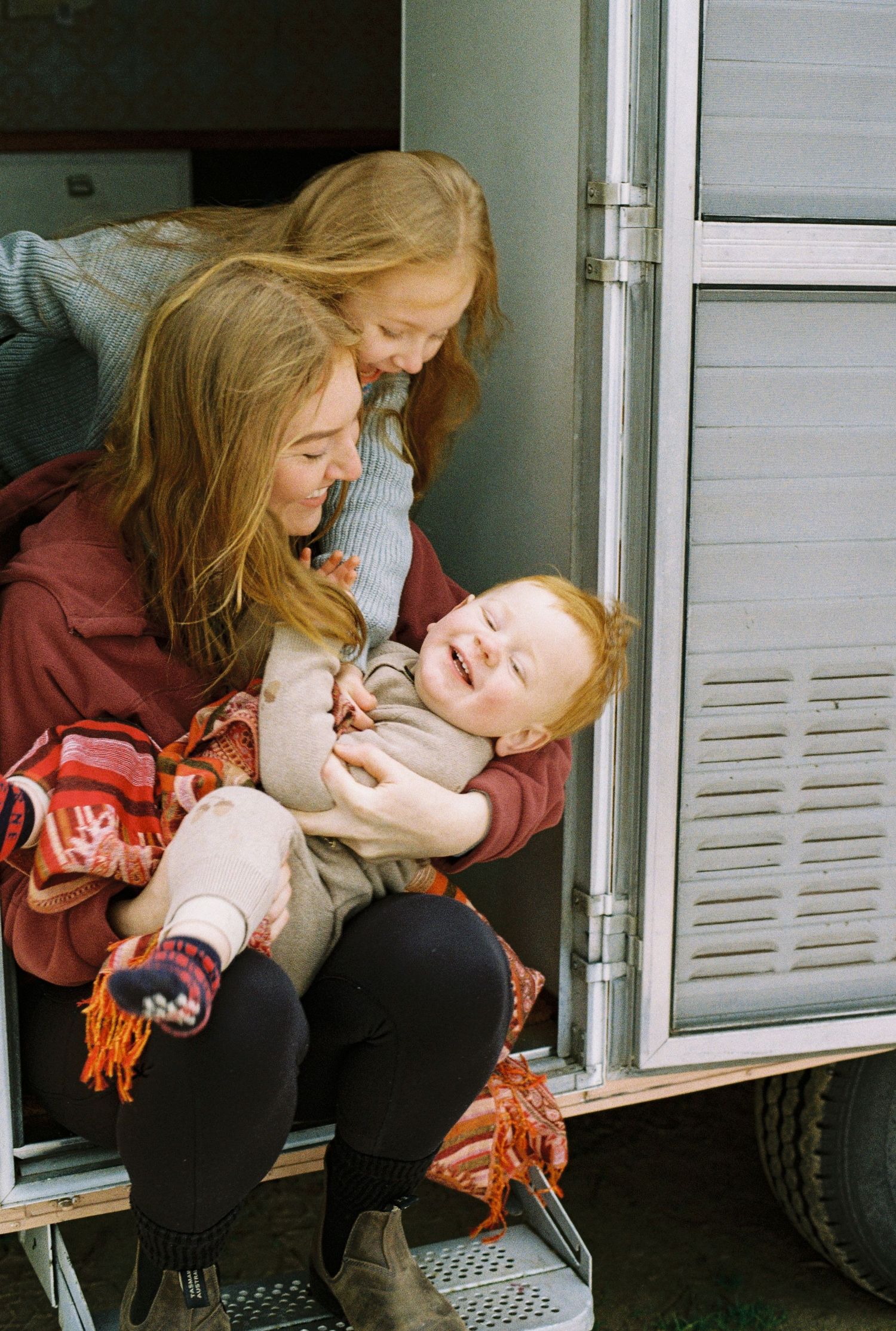 family cuddling inside caravan captured on 35mm film
