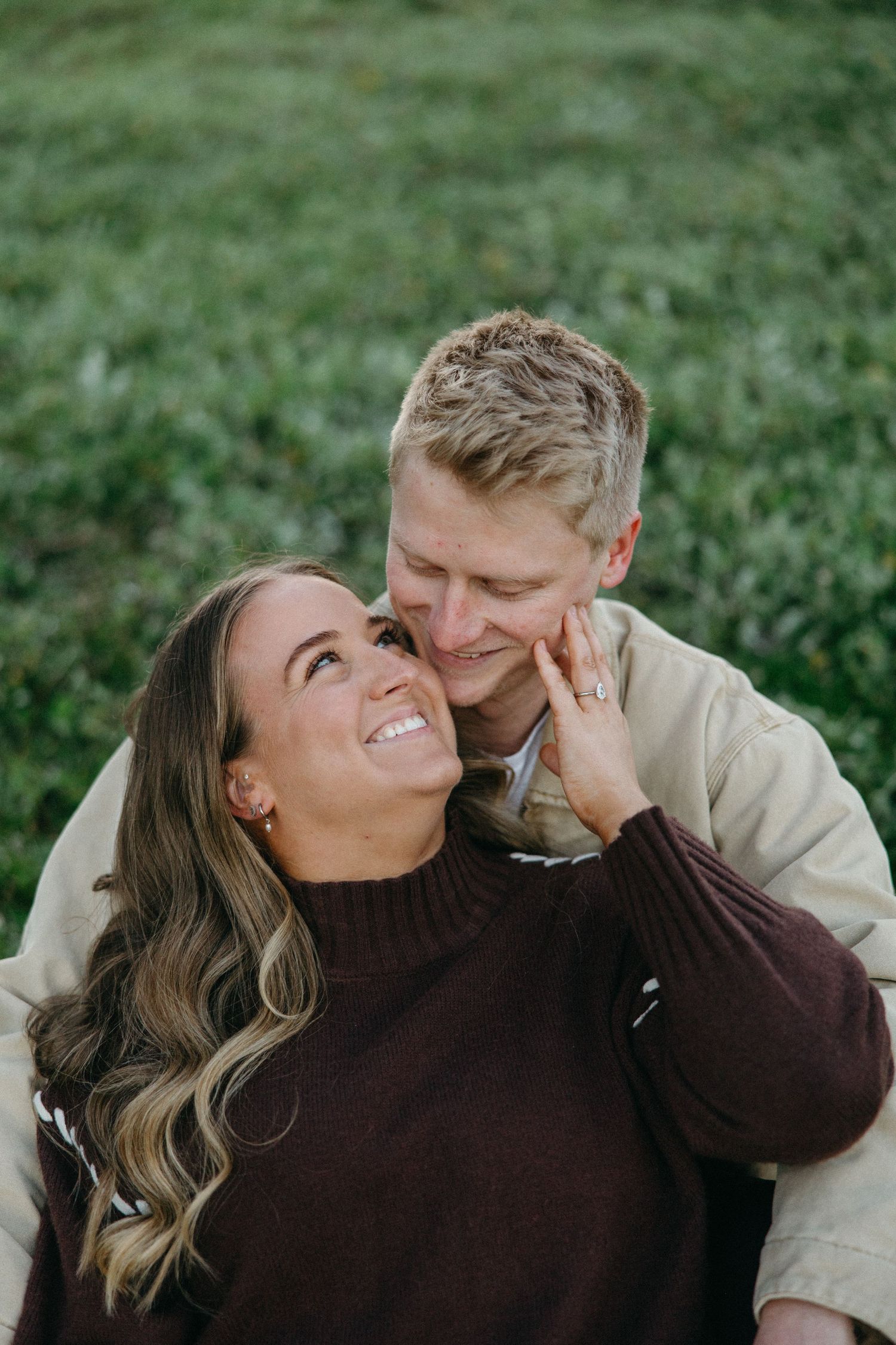 woman leaning into her partners arms on the grass