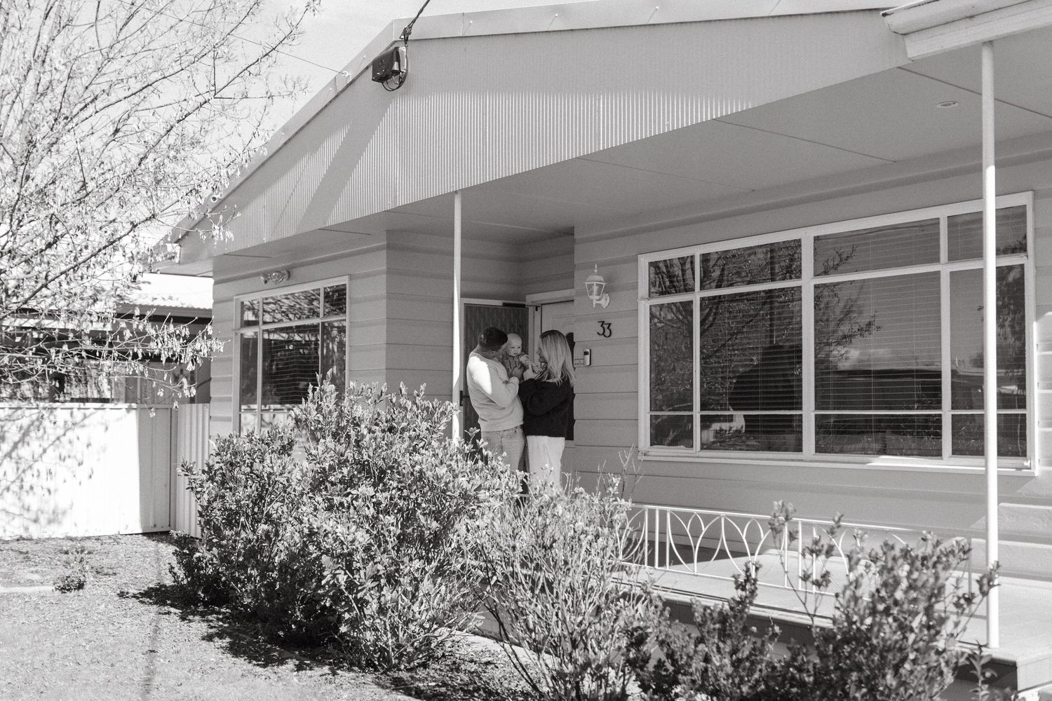 family standing on the porch of their family home