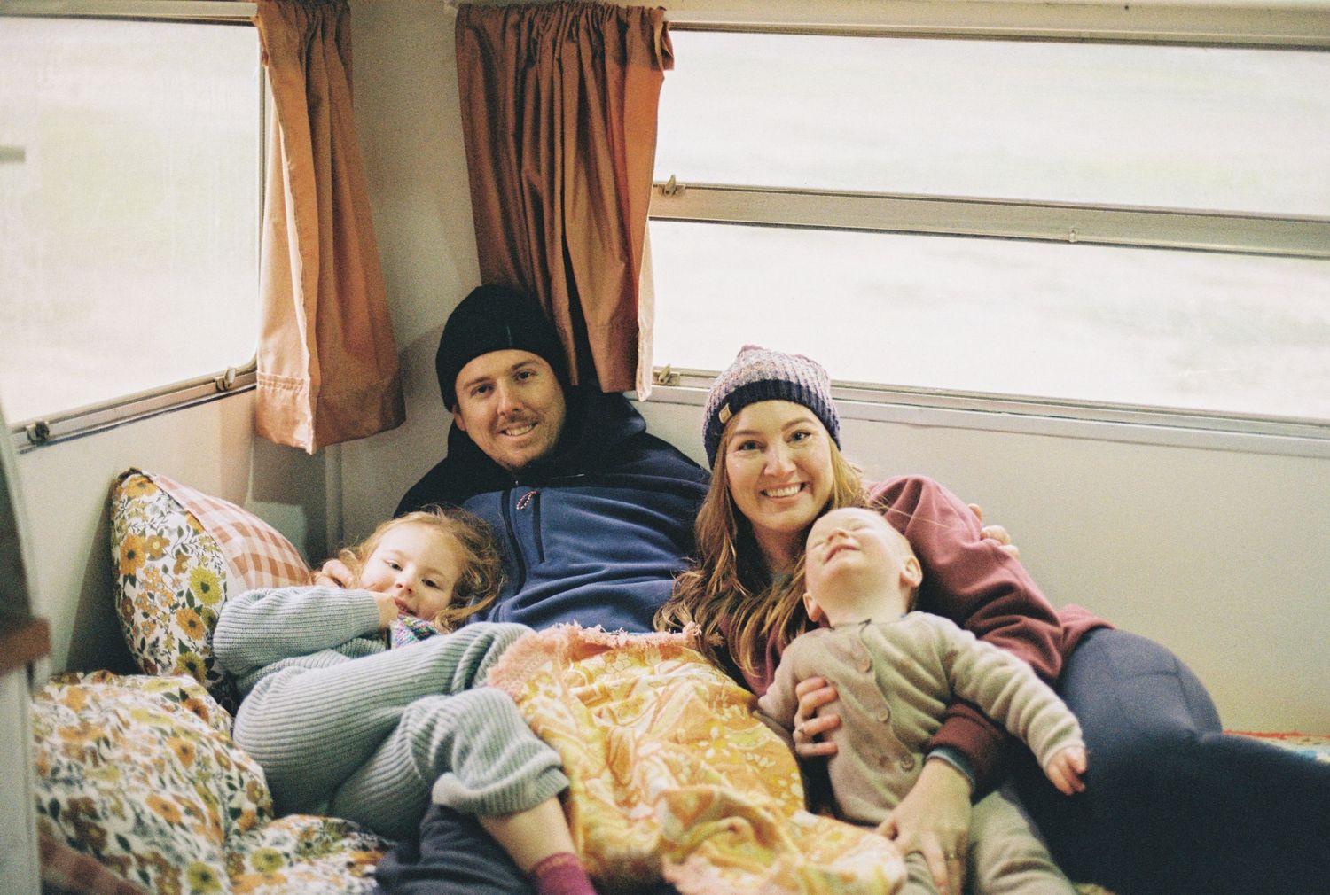 family cuddling inside caravan captured on 35mm film