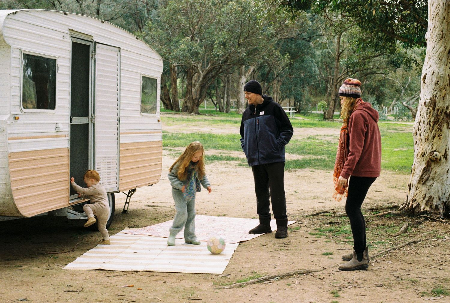family kicking a ball outside caravan captured on 35mm film