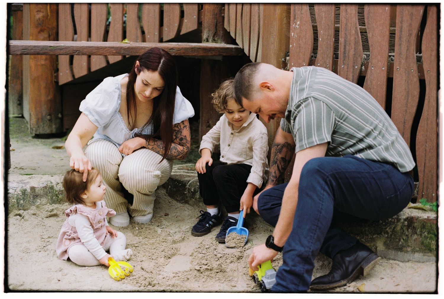 family playing in sandpit captured on35mm film