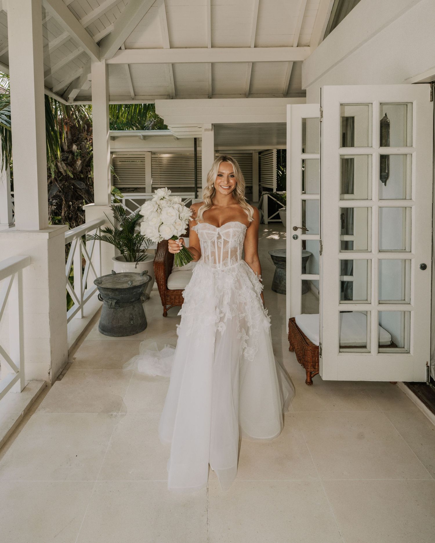 Bright white wedding venue interior with French doors and elegant bridal gown.