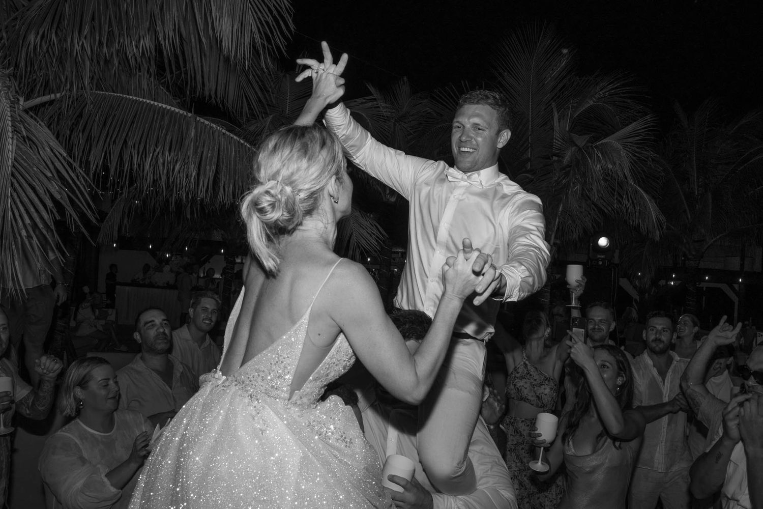 Black and white photos of wedding guests dancing and celebrating on a dance floor at a reception.