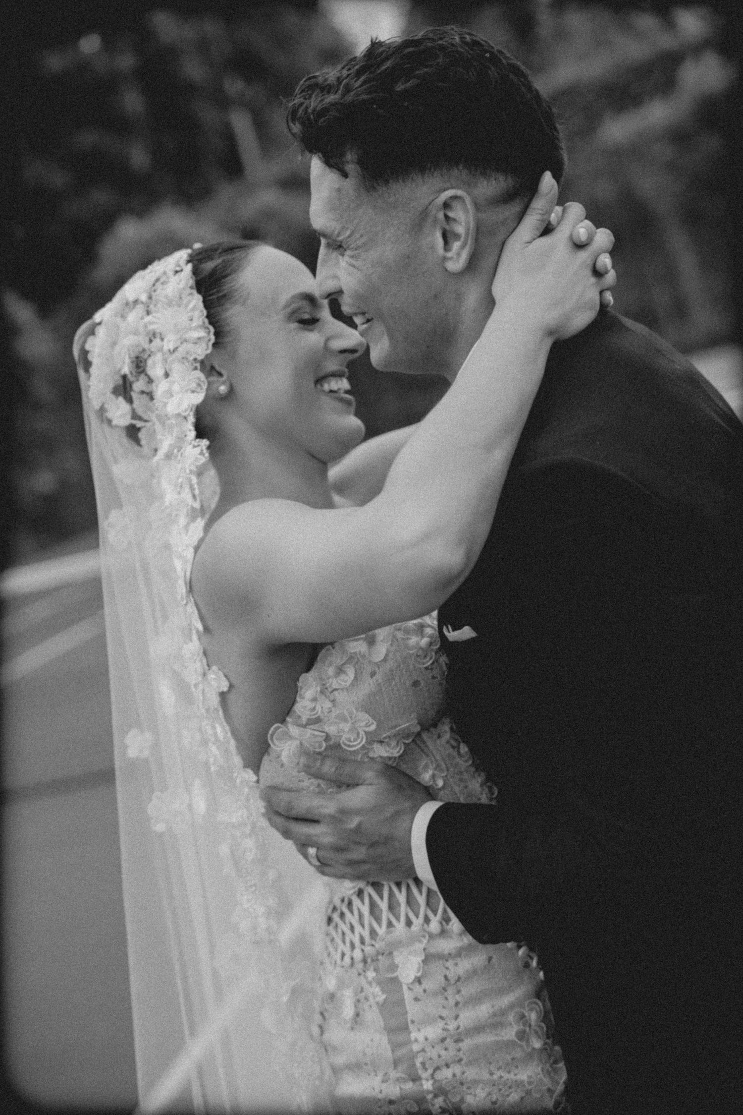 A tender black and white wedding moment captured as the bride and groom share an intimate kiss.