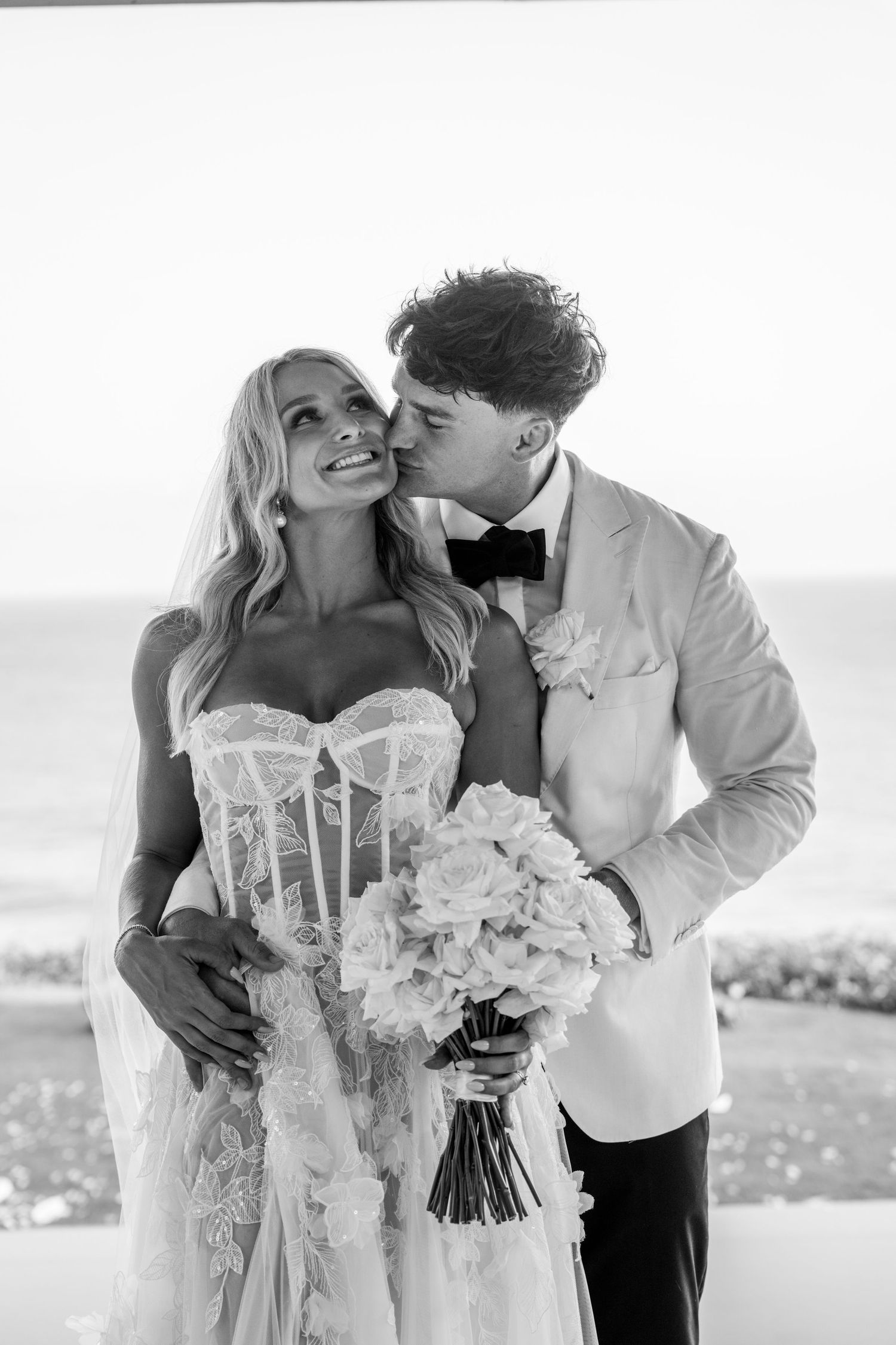 Black and white romantic wedding photos showing intimate moments with white bridal bouquet.