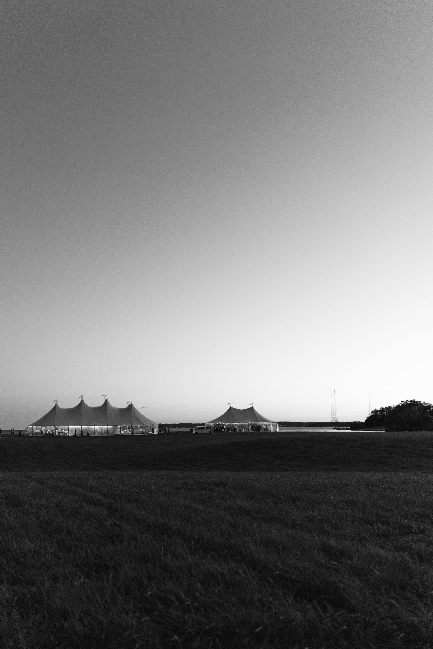 Silhouette of wedding tents on horizon against dramatic evening sky.